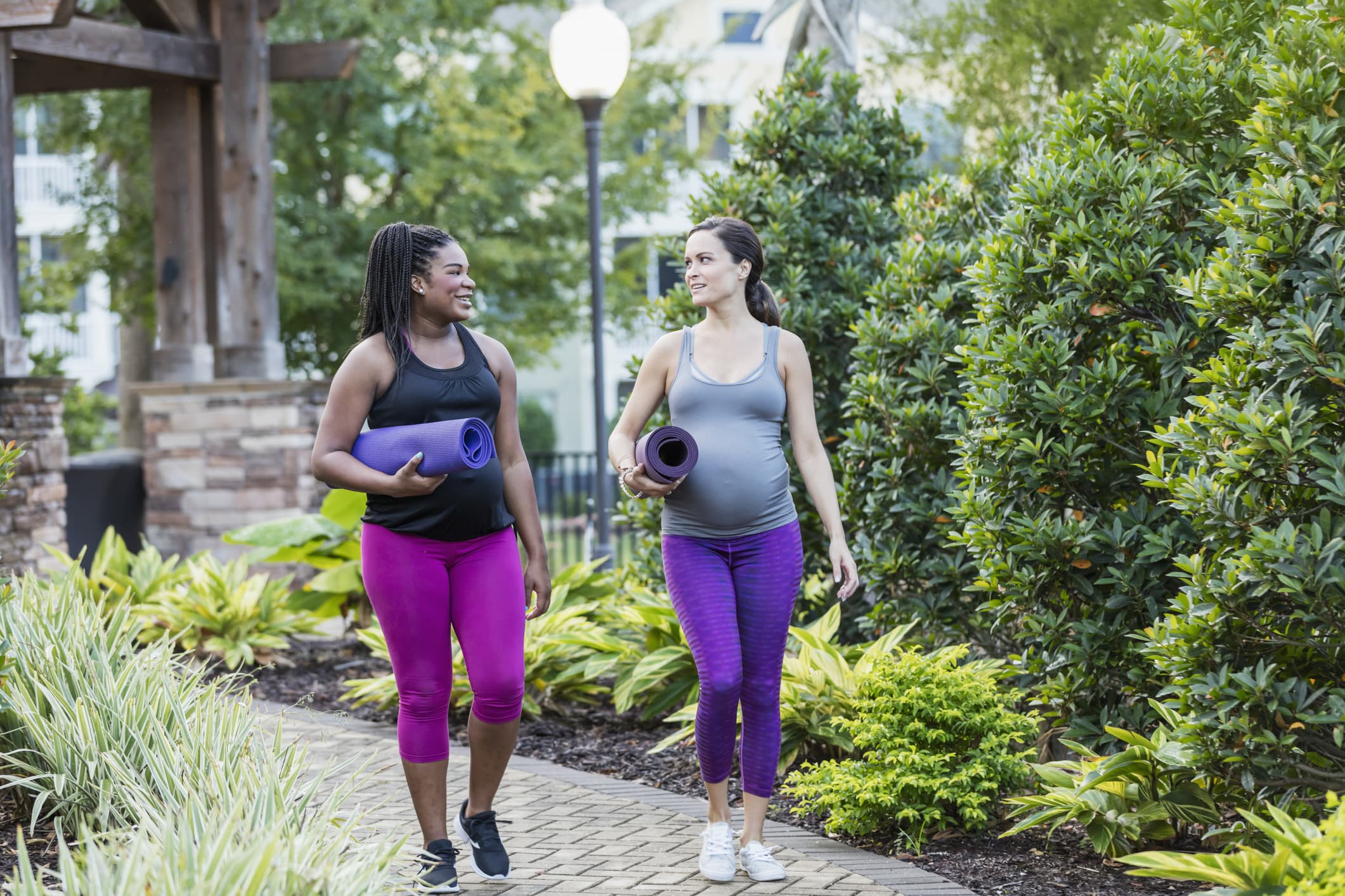 Two multi-ethnic pregnant women walking to yoga class