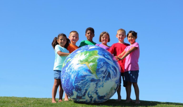 Portrait of multi-ethnic kids with large earth ball