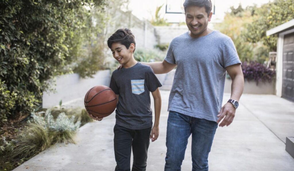 Father and son walking back inside after playing basketball outdoors
