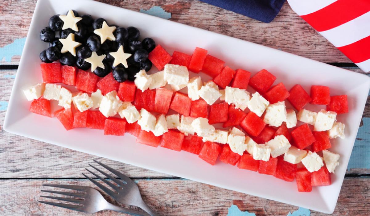 American flag salad with watermelon, blueberries and feta cheese. Top view table scene against a wood background.