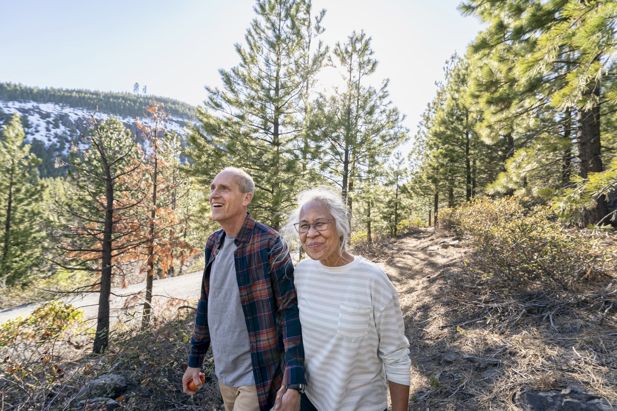 Active retired couple hiking in forest