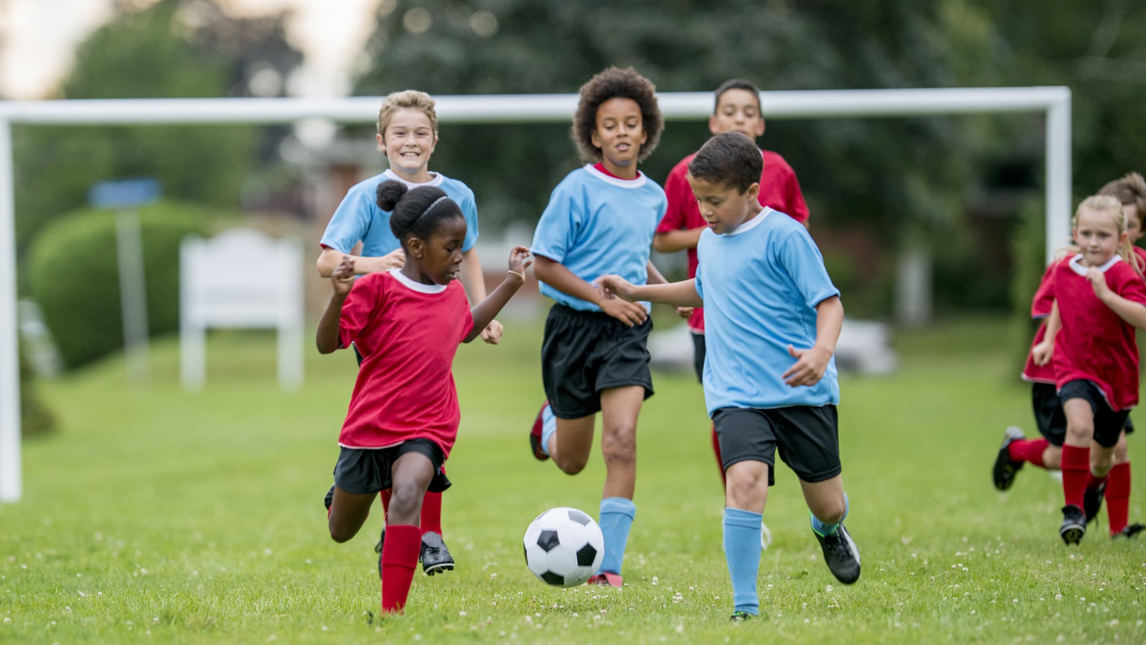 Children Chasing Soccer Ball During a Match