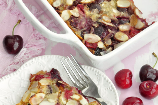 Cherry puff pancake in a pan with a slice of the pancake on the side