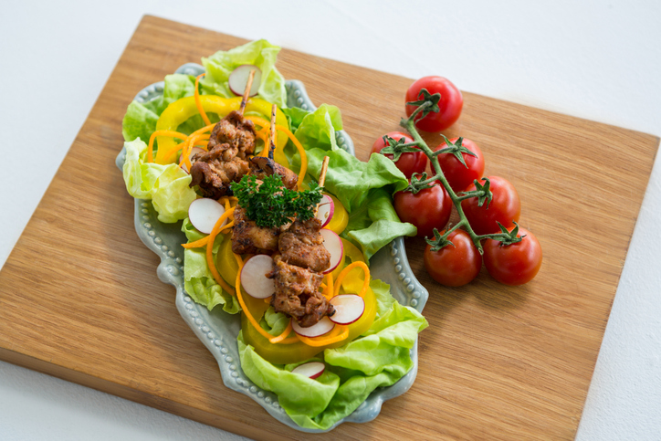 Close-up of vegetable salad and cherry tomato on wooden board