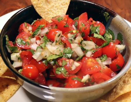 bowl of cherry tomato salsa with corn ships