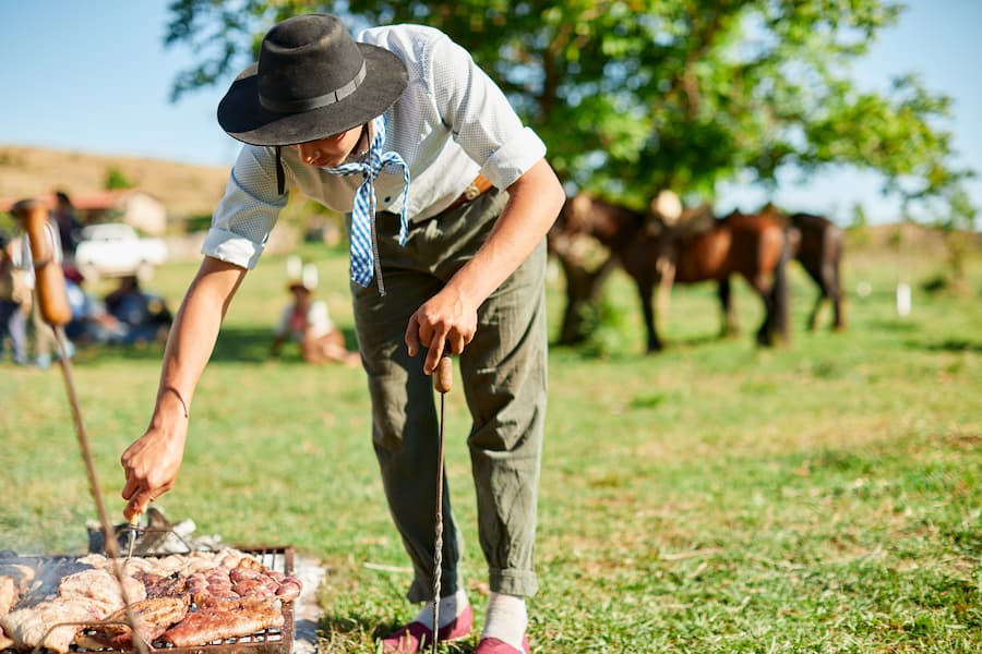 Young gaucho grilling meat in the traditional Argentinian way.