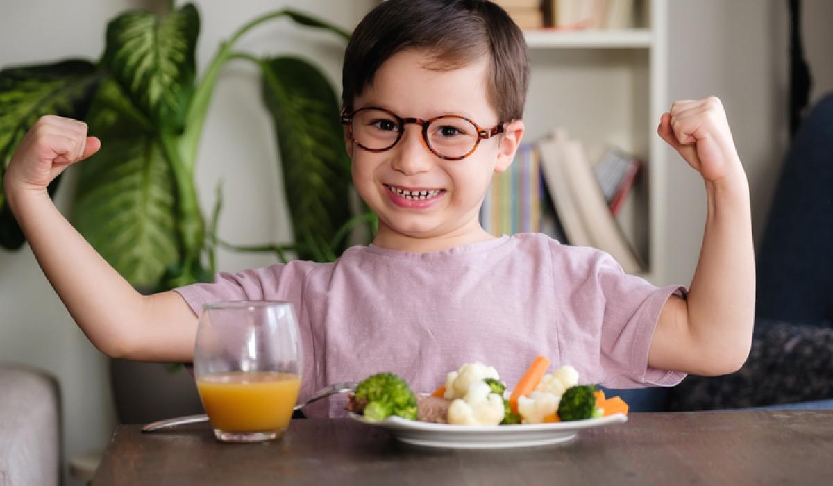 Child is very happy with having to eat vegetables. There is a lot of vegetables on his plate. He loves vegetables.