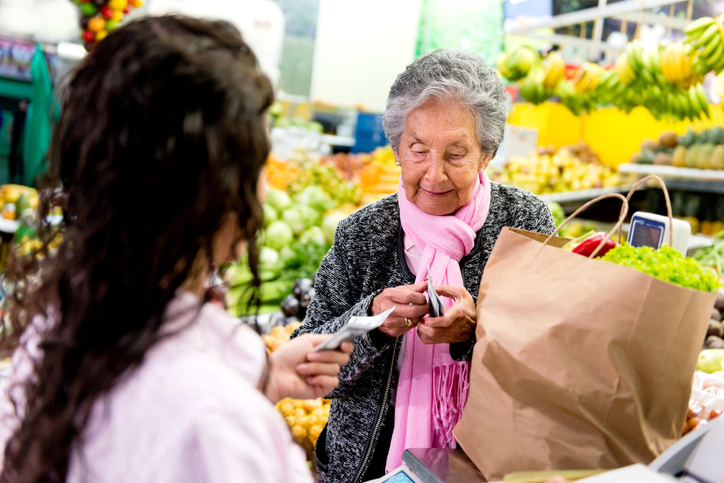 Woman customer paying at the supermarket after buying groceries
