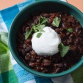 A bowl of black Bean Chili with a dollop of sour cream on top.