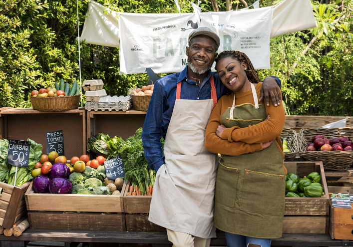 Greengrocer selling organic fresh agricultural product at farmer market