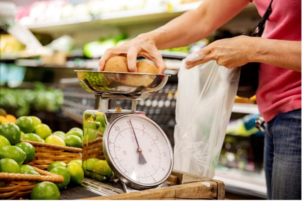A person weighing produce at a grocery mart.