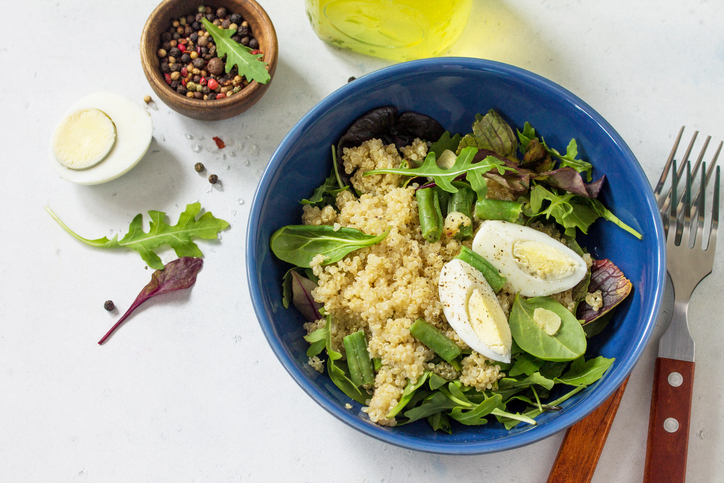 Diet menu, Vegan food. Healthy salad with quinoa, arugula, green Beans and Eggs on a white stone table. Copy space.