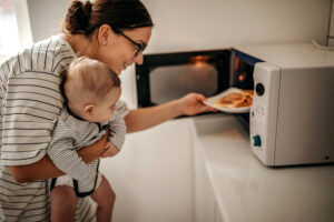 Mother preparing food with baby in arms