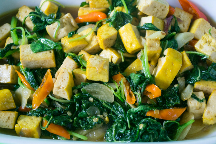 Close up view of stier fried tofu with spinach, simple and healthy home cooking commonly found in Indonesian household