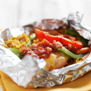 baked mexican chicken fajitas with spanish rice in foil packet shot with selective focus