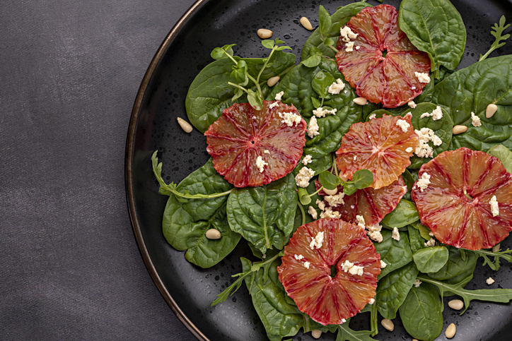Macro food photography of salad with red orange, feta, spinach, arugula, pine nuts, vegetable, homemade, rocket