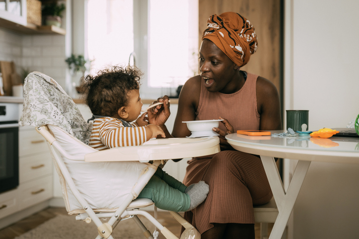 Mom feeding her baby boy at home