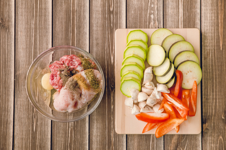 Food and fresh ingredients on wooden table with copy space. Marrow squash, vegetable, meet, ground beef, pork, mushroom, egg, seasoning, onion, chicken garlic on the desk.