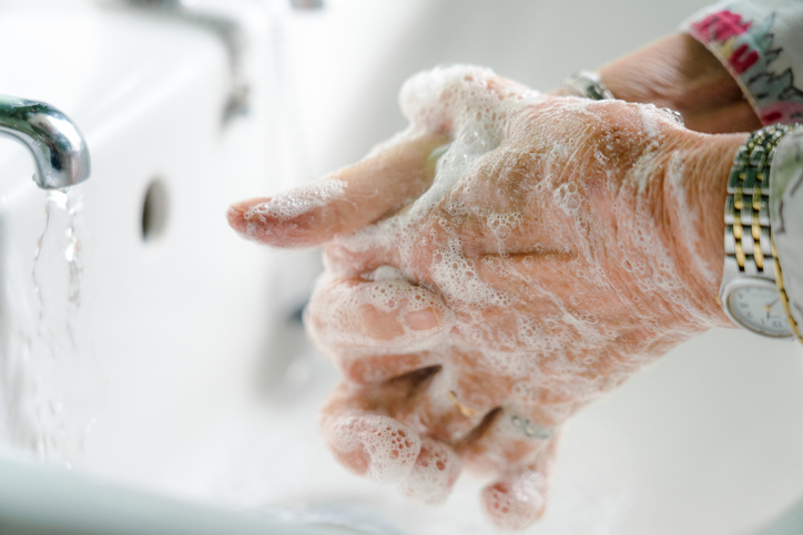 Senior woman carefully washing her hands