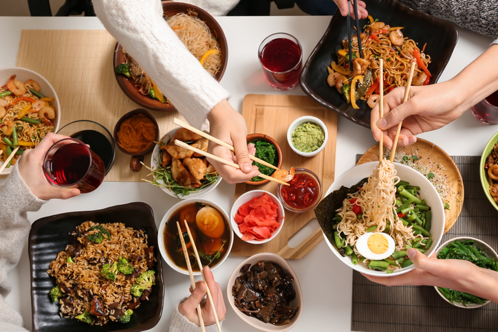 Friends eating tasty Chinese food at table