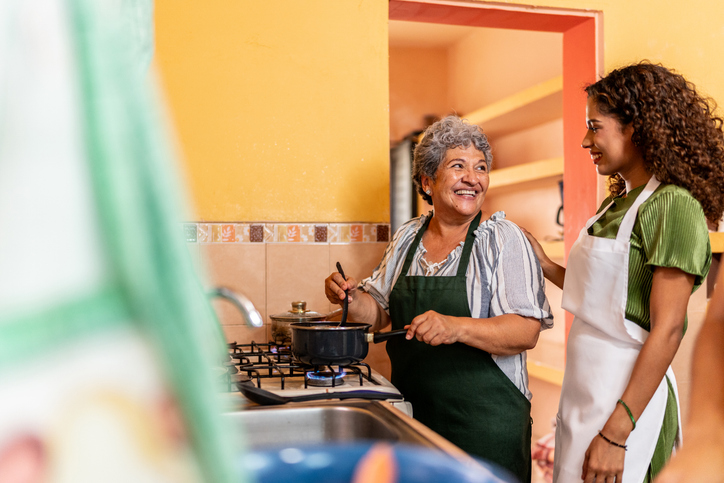 Young woman cooking with grandmother in the kitchen at home