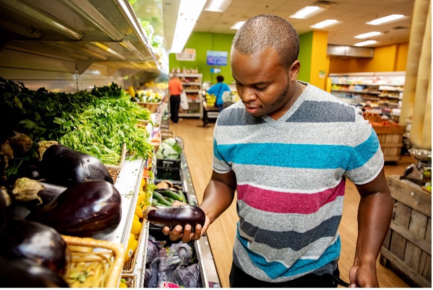 Young man shopping for vegetables in s grocery market