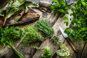 Fresh scented organic herbs for cooking shot on rustic kitchen table