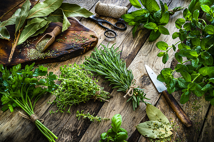Fresh scented organic herbs for cooking shot on rustic kitchen table