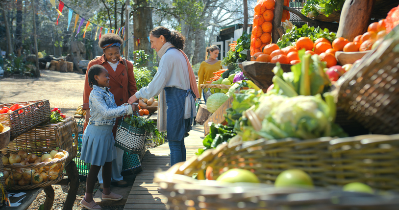 Service, worker and family for shopping at market with friendly assistance, vegetables purchase and fresh produce. Outdoor, black people and happy at farmers stall for discount product and fruit sale
