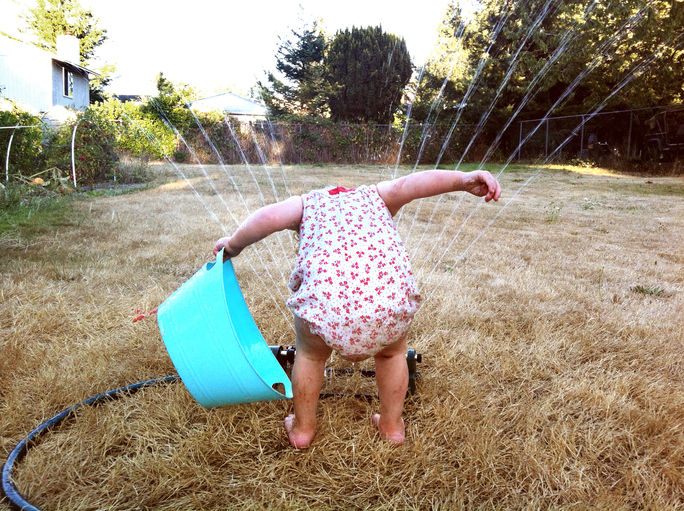 Girl Playing in Sprinkler