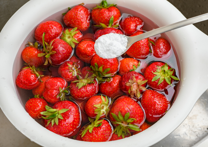Rinsing fresh strawberry fruit in water with the addition of baking soda