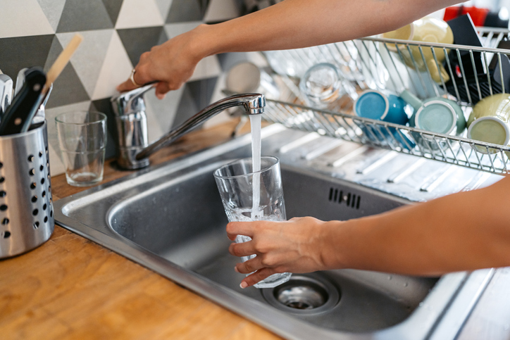 Young Woman Filling A Glass Of Water In The Sink