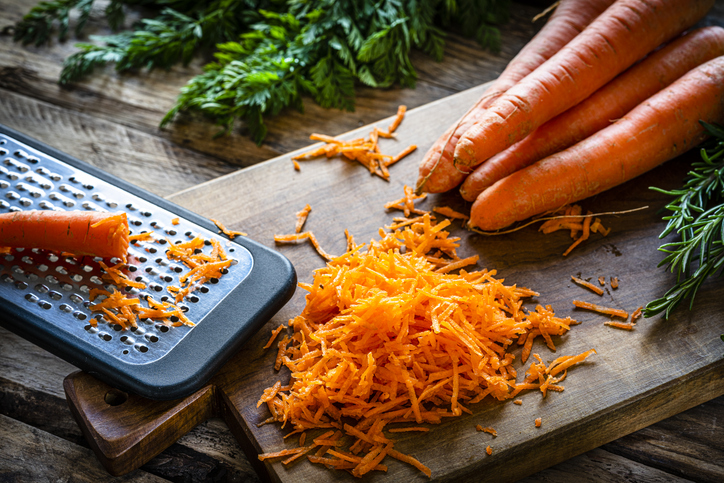 Fresh organic shredded carrots on cutting board
