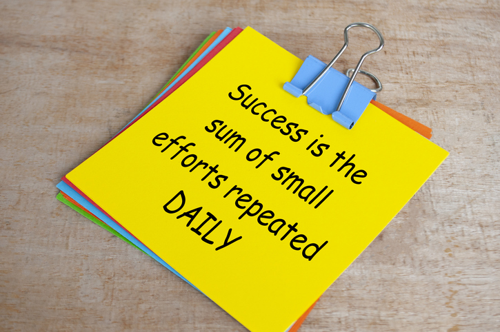 Success is a sum of small efforts repeated daily text on yellow notepad. Encouragement concept