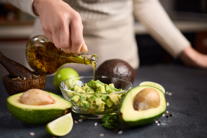 Chopped avocado in glass bowl and avocado Halves