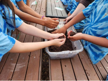 A group of students working with dirt for gardening purposes